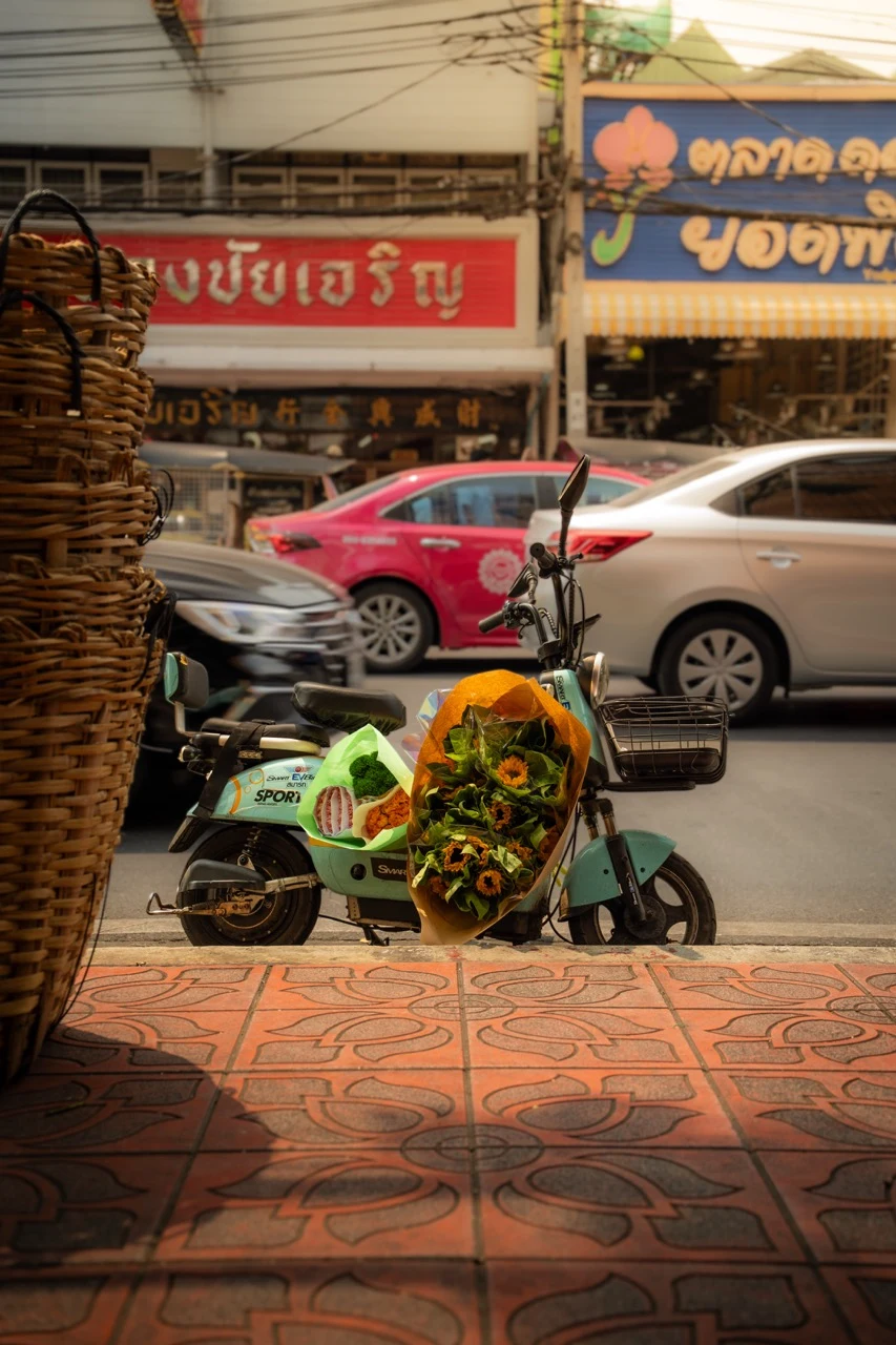 A street scene with a scooter in the foreground